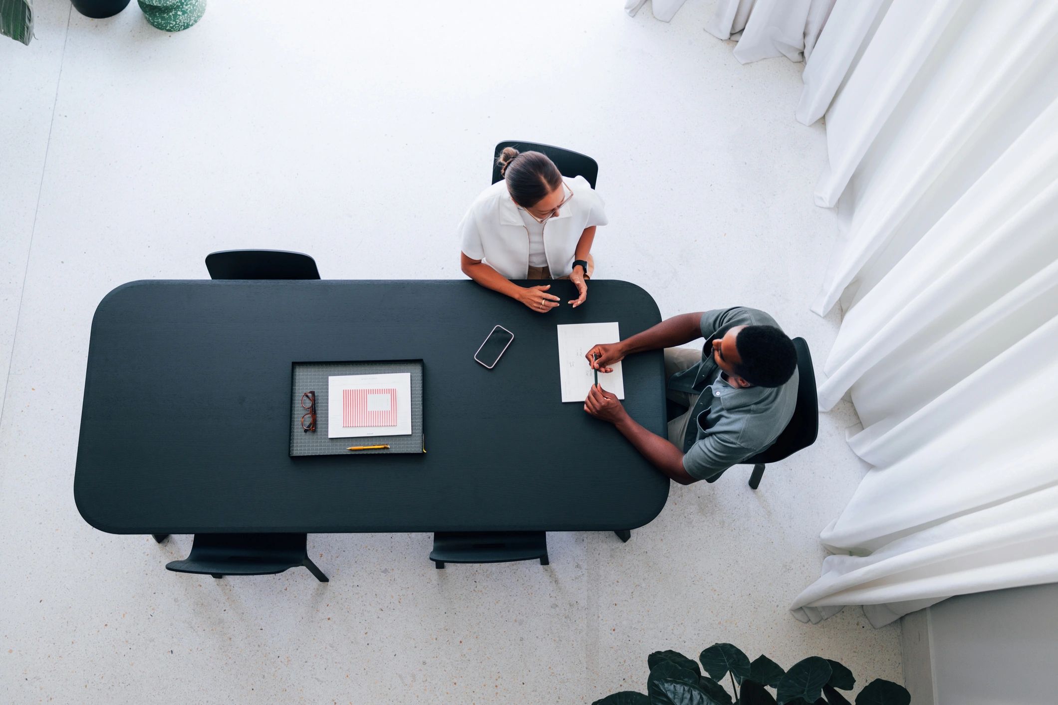 Two colleagues reviewing documents during a research meeting