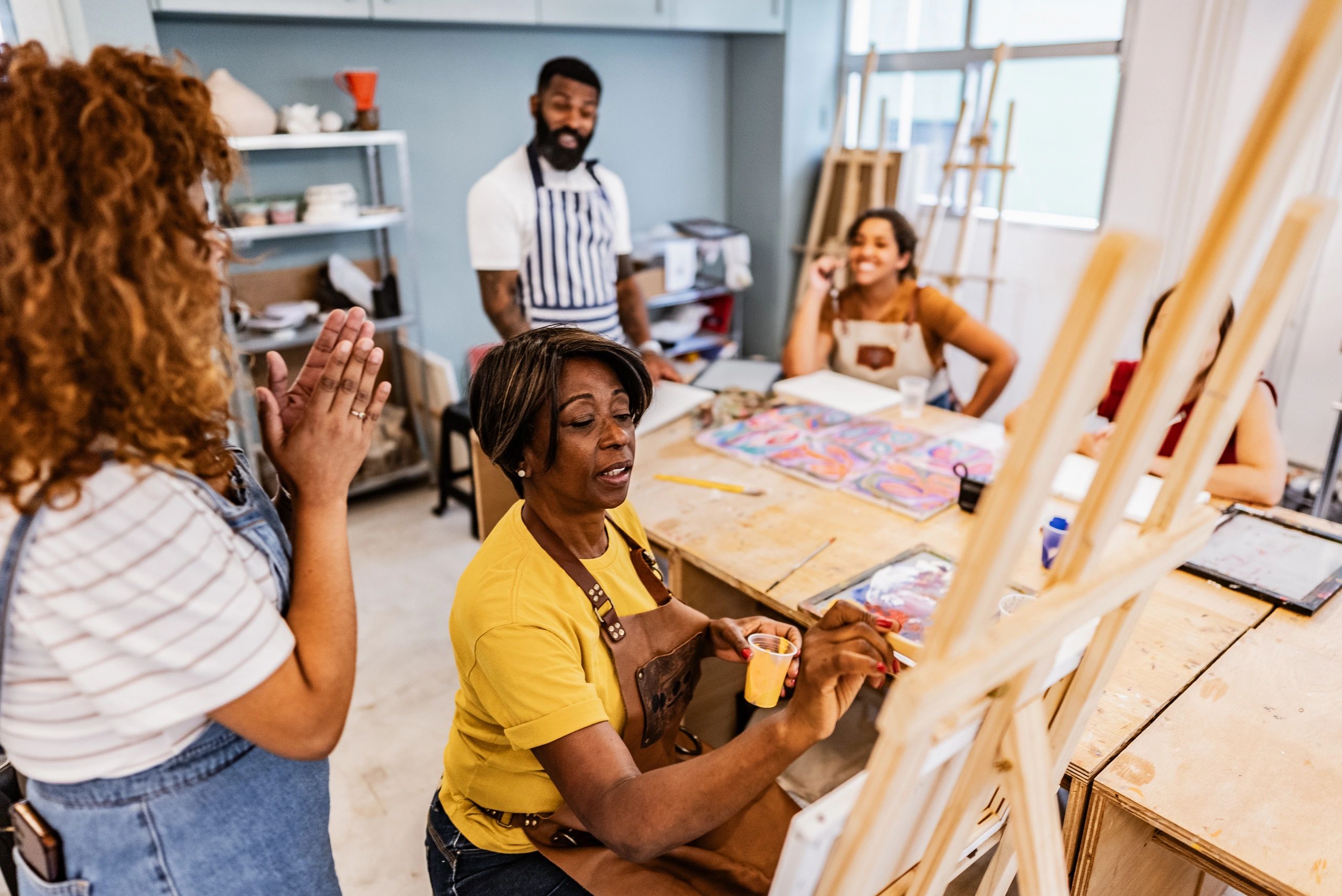 Instructor demonstrating painting techniques in an art class