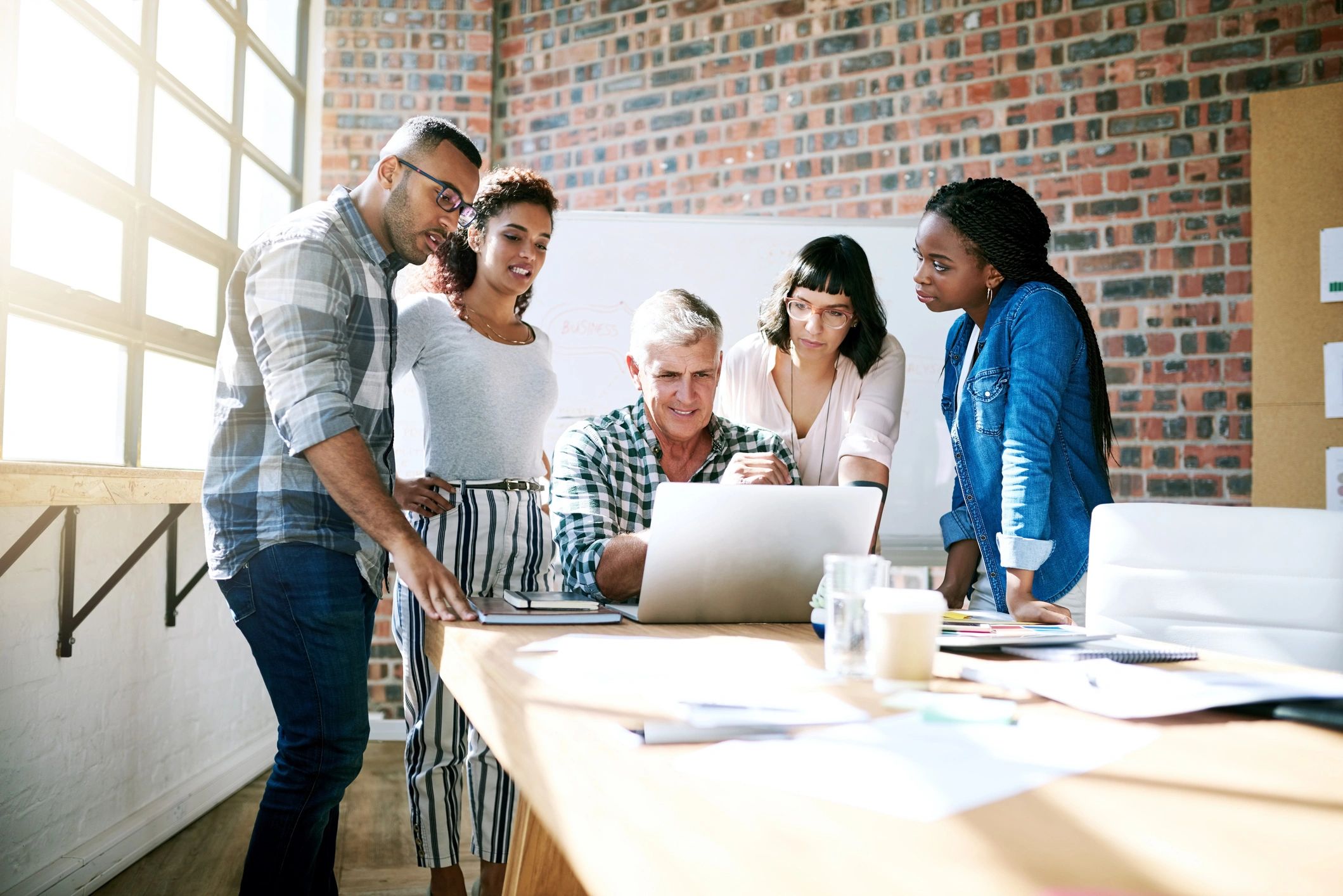 Creative team collaborating around a laptop